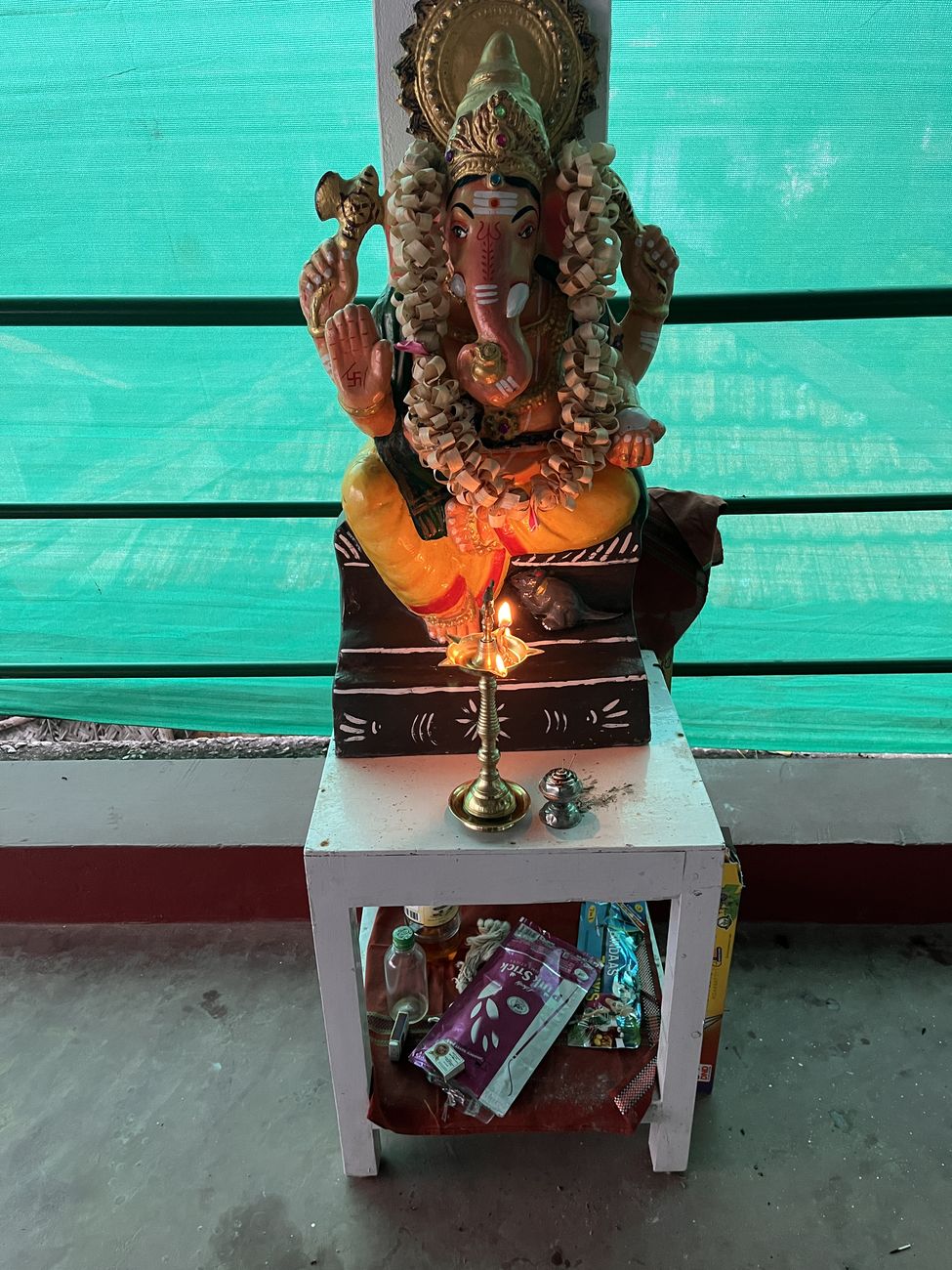 A Ganesh statue with an oil lamp