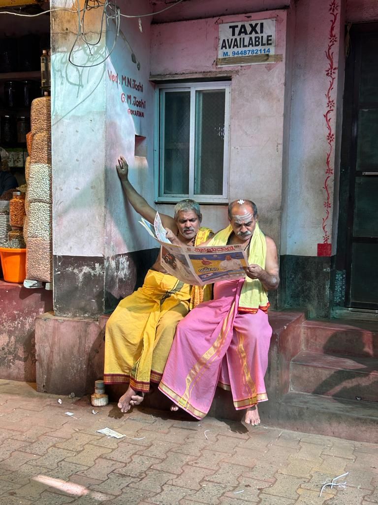 Two women in saris reading the newspaper